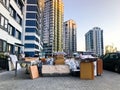 Many different things of furniture stand unloaded on the street near the house of the skyscraper new building. Concept