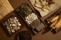 Many different types of herbal medicine are featured on paper and wooden dishes.