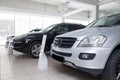 Many different used cars are in the dealership of a dealer accepted by the trade-in system during a sale in a bright room with