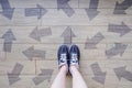 Many Direction Arrow Choices. Selfie of Running Shoes with Drawn Arrows. Woman Violet Sneakers with Decisions on Wooden Floor Back Royalty Free Stock Photo