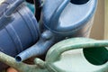 Many dirty watering cans criss-cross each other