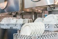 Many dish or white plate arranged on basket for cleaning by automatic dishwasher machine in kitchen room restaurant Royalty Free Stock Photo