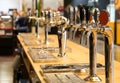 Beer taps lined up on the counter of a pub