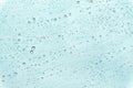 Many droplets on car window in rainy day with blue background
