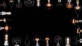 Many Edison lamps blinking over black, copyspace frame, looped