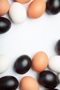 Many eggs of different colors on white background. Black, white and brown eggs. Royalty Free Stock Photo
