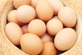 Many eggs. Straw hat. Chicken eggs in wooden basket on green nature floor at cloudy day. Backdrop. Organic food Royalty Free Stock Photo