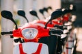 Many Electric Motorbikes, Motorcycles Scooters Parked In Row In City