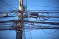 Many electrical and communication cables are entangled in a mess on the power poles. Confusing and insecure concept to operate and Royalty Free Stock Photo