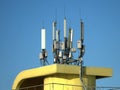 Many electronics aerials on yellow building top Royalty Free Stock Photo