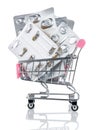 Many empty blister packs of tablets and pills in chromed toy market shopping cart with pink handle isolated on white background Royalty Free Stock Photo