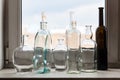 Many empty bottles on windowsill and view of park