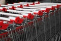 Many empty metal shopping carts near supermarket outdoors, closeup Royalty Free Stock Photo