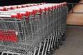 Many empty metal shopping carts near supermarket outdoors, space for text Royalty Free Stock Photo