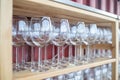 many empty wine glasses arranged on wooden shelves Royalty Free Stock Photo