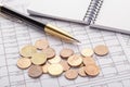 Stack of euro euro coins on old black wooden table. Pen, notebook and accounting documents with numbers Royalty Free Stock Photo