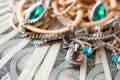 Many expensive golden and silver jewerly rings, earrings and necklaces on big amount of US dollar bills close up. Pawnshop or Royalty Free Stock Photo