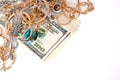 Many expensive golden and silver jewerly rings, earrings and necklaces with big amount of US dollar bills on white background. Royalty Free Stock Photo