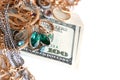 Many expensive golden and silver jewerly rings, earrings and necklaces with big amount of US dollar bills on white background. Royalty Free Stock Photo