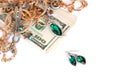 Many expensive golden and silver jewerly rings, earrings and necklaces with big amount of US dollar bills on white background. Royalty Free Stock Photo