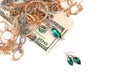 Many expensive golden and silver jewerly rings, earrings and necklaces with big amount of US dollar bills on white background. Royalty Free Stock Photo