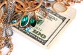 Many expensive golden and silver jewerly rings, earrings and necklaces with big amount of US dollar bills on white background. Royalty Free Stock Photo