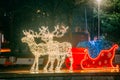 Many Festive Lights Lamps In Shape Deers Harnessed To A Christmas Sleigh. Night Festive Illumination. Decorative Streets