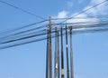 Many fiber internet communication cables on power poles with blue sky background