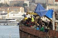 Many fishermen stand aboard an old rusty ship near the shore. The Golden Horn, Ayakap