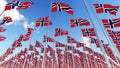 Many flags of Norway on flagpoles against blue sky. Royalty Free Stock Photo