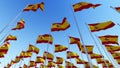 Many flags of Spain waving against blue sky. Royalty Free Stock Photo