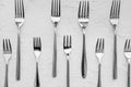 Many forks on white textured background, flat lay