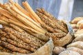 many fresh bread sticks with salt and seeds in paper bags and other bakery around. degustation of bread. Catering and