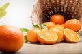 Many fresh oranges in a wooden basket placed on the floor. There are some balls that have been cut in half to make them look appet Royalty Free Stock Photo