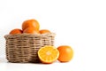 Many fresh oranges in a wooden basket placed on the floor. There are some balls that are cut in half to make them look appetizing. Royalty Free Stock Photo