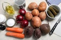 Many fresh vegetables and other ingredients on white wooden table, flat lay. Cooking vinaigrette salad