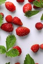 Many fresh wild strawberries and leaves on white background, flat lay Royalty Free Stock Photo