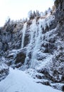 Many frozen waterfalls with extreme ice climbers on them on a cold winter day in the Dolomites in Italy