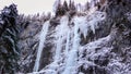 Many frozen waterfalls with extreme ice climbers on them on a cold winter day in the Dolomites in Italy