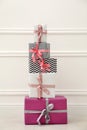 Many gift boxes with colorful bows near white wall Royalty Free Stock Photo