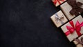 Many gift boxes wrapped in brown paper and tied with different ribbons on a black background, top view, copy space.Christmas and Royalty Free Stock Photo