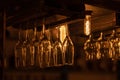 Many glass goblets for wine, champagne, martini, alcoholic drinks hang upside down above the bar. Warm evening light, Royalty Free Stock Photo