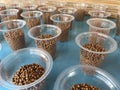 Many glass plastic filled with dry fish food pellets.