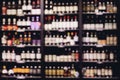 Many glass wine bottles on shelves interior in restaurant. Blurred background