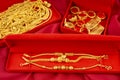 The Many gold necklaces and gold bars in red box on red velvet cloth background Royalty Free Stock Photo