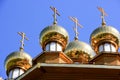 Golden domes of wooden church on bright blue sky background Royalty Free Stock Photo