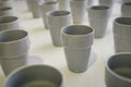 Many gray ceramic cups stand on the table