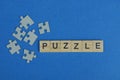 Many gray paper puzzles and a word made of wooden letters