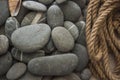 Many gray pebbles with hemp rope background, space for text Royalty Free Stock Photo