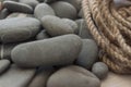 Many gray pebbles with hemp rope background, space for text Royalty Free Stock Photo